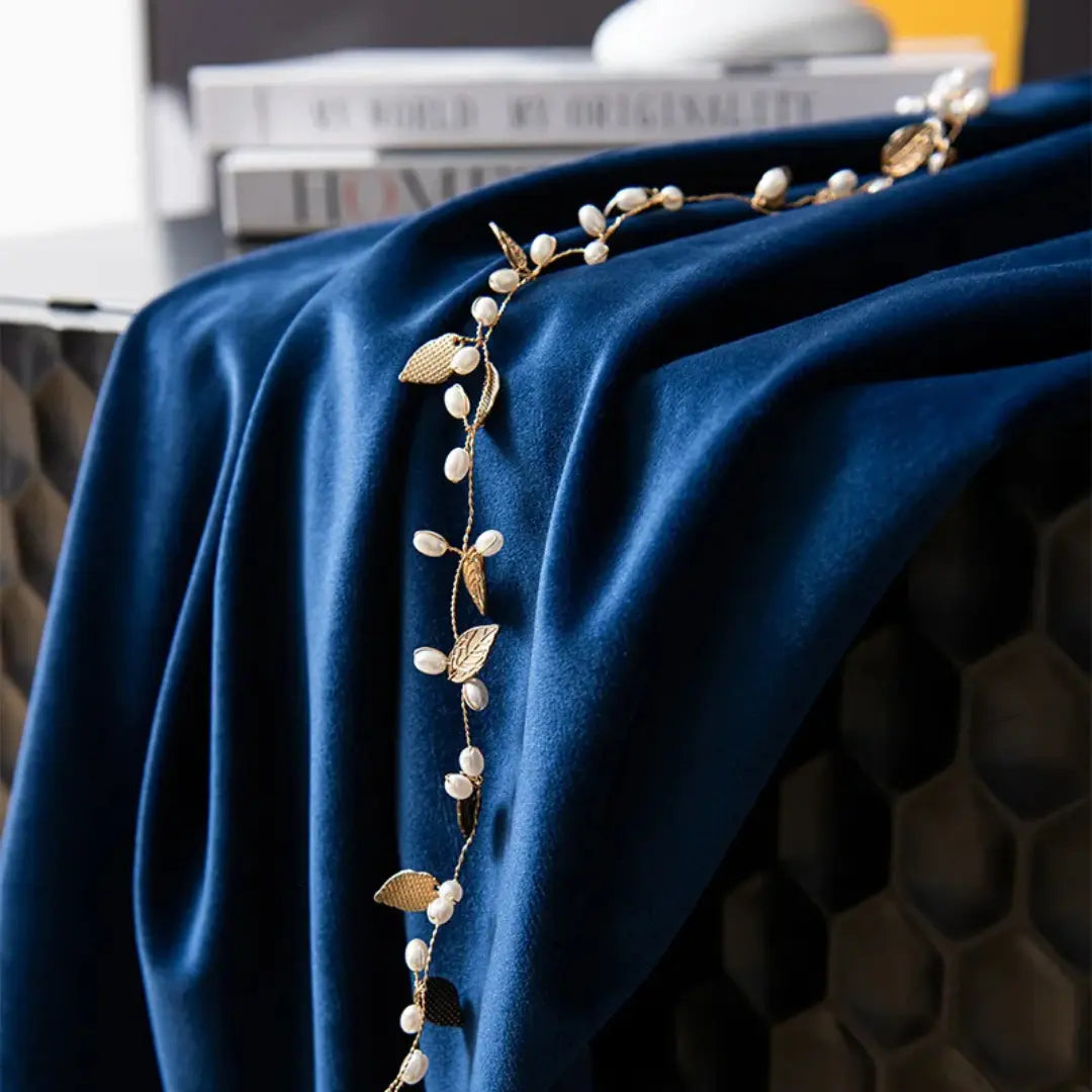 Veludo azul da Étoile Royale em close, com pregas profundas e amarração decorativa dourada