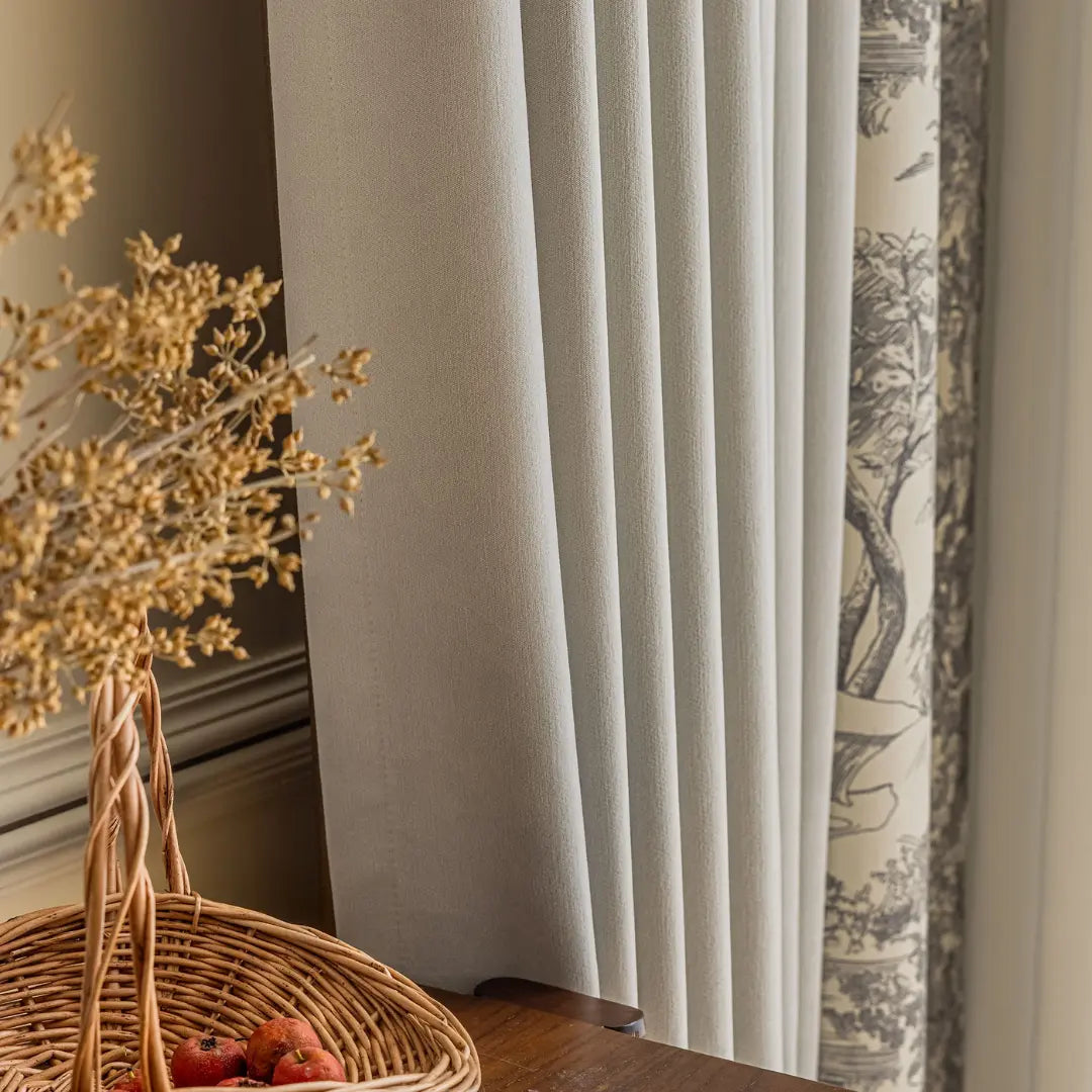 Pregas do tecido cinza liso e faixa estampada da Cortina Sylvana em ambiente com vaso decorativo
