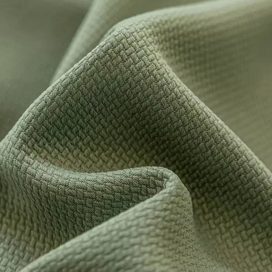 Detalhe da trama jacquard verde da Cortina Valeriana disposta em dobras arredondadas