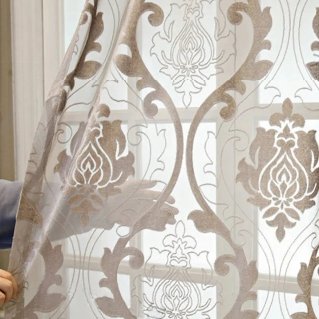 Cortina Fiorenza Coffee em close contra a luz, revelando medalhões florais e áreas translúcidas no jacquard