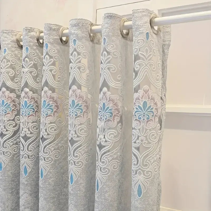 Ilhoses metálicos da Cortina Winterfell no varão, acima do padrão bordado cinza e turquesa
