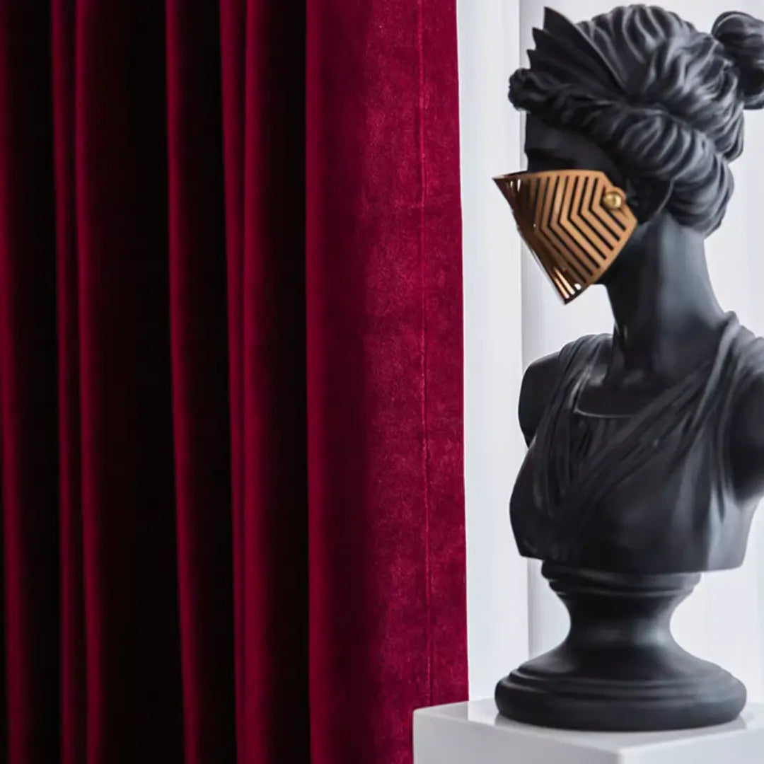 Pregas da Cortina Vionelle em veludo vinho ao lado de escultura preta com detalhe dourado