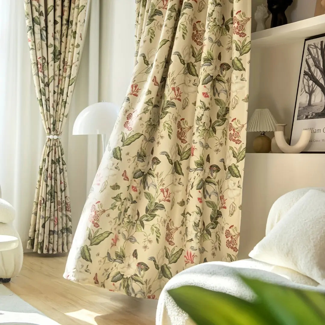 Cortina Floral Rosê drapeada junto à poltrona, destacando o desenho botânico em tons rosados e verdes
