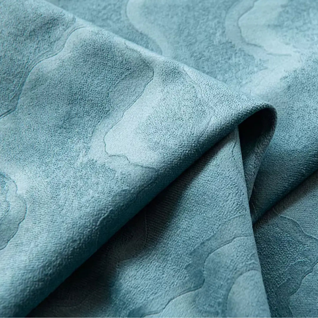 Detalhe do veludo azul da Cortina Verdôme dobrado, com desenho orgânico em relevo tonal