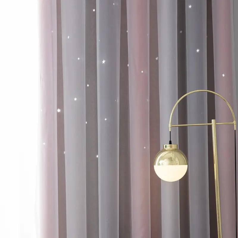 Cortina Sonhos de Princesa Rapunzel em detalhe das faixas rosa e cinza junto a luminária dourada, com estrelas iluminadas
